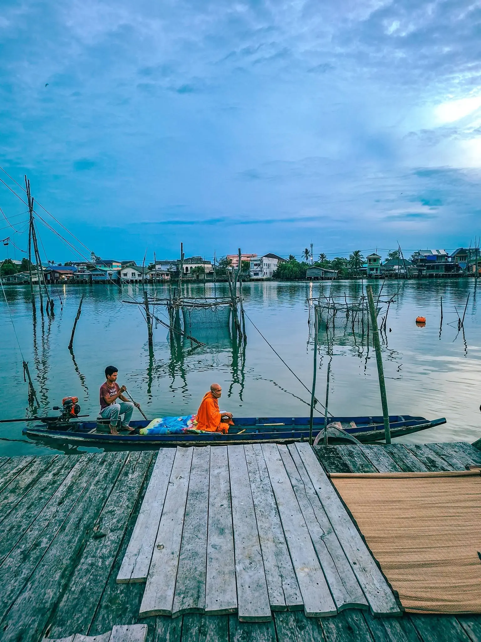 เรือประมงลำเล็กในแม่น้ำยามพลบค่ำ