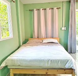 เตียงนอนในห้องพัก 2 ท่าน ผนังสีเขียว